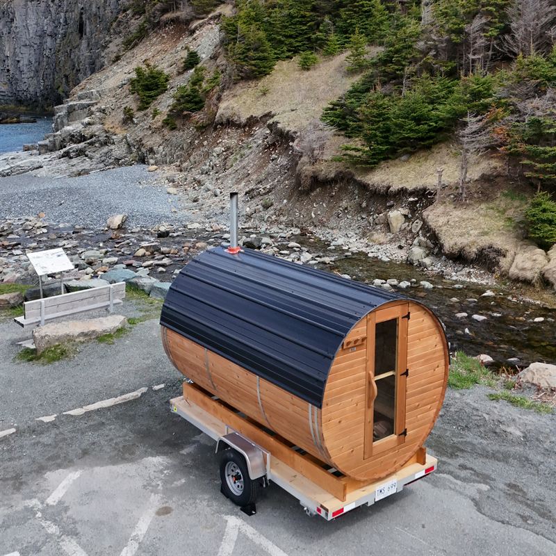 Wood-fired barrel sauna trailer in winter
